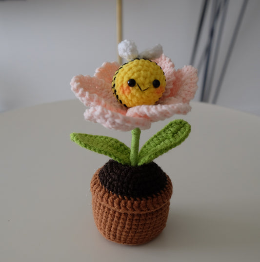 Handmade crochet potted plant features a beautiful blossom