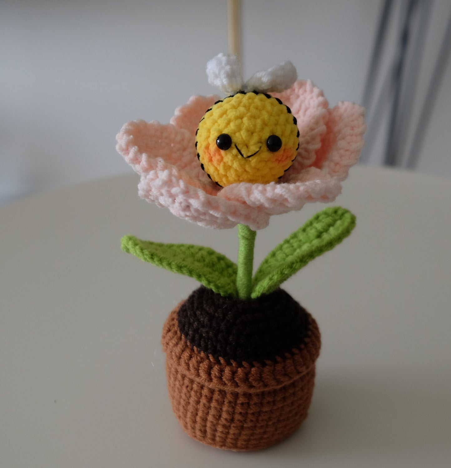 Handmade crochet potted plant features a beautiful blossom