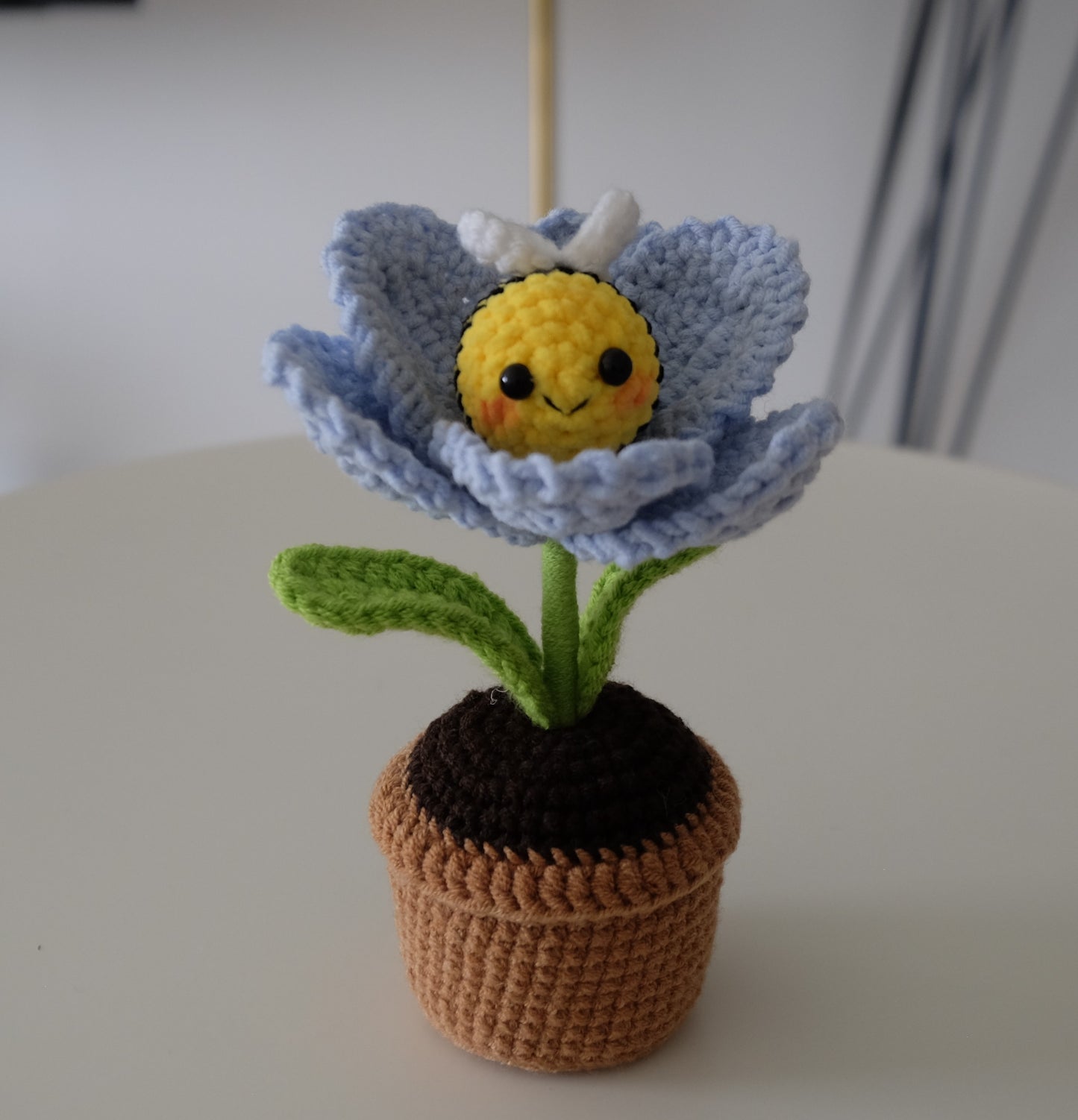 Handmade crochet potted plant features a beautiful blossom