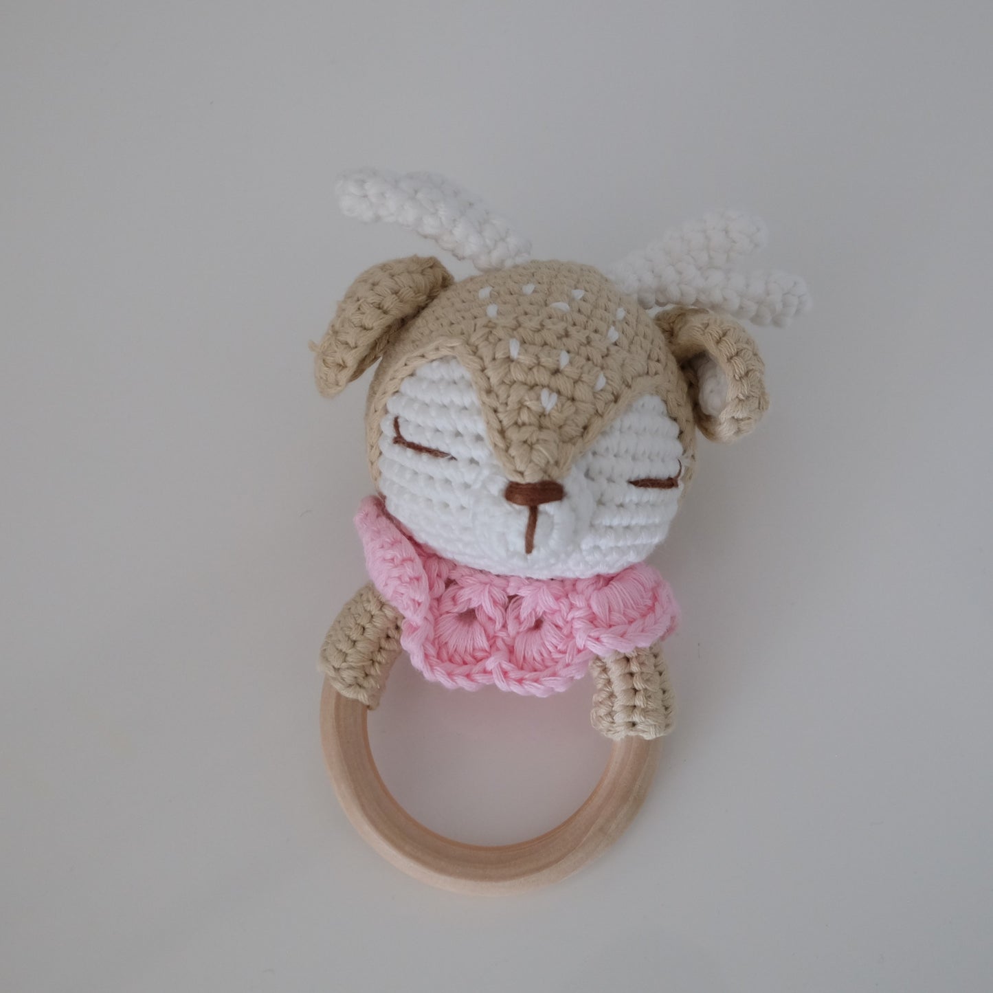 Handmade crochet rattle with a wooden ring base
