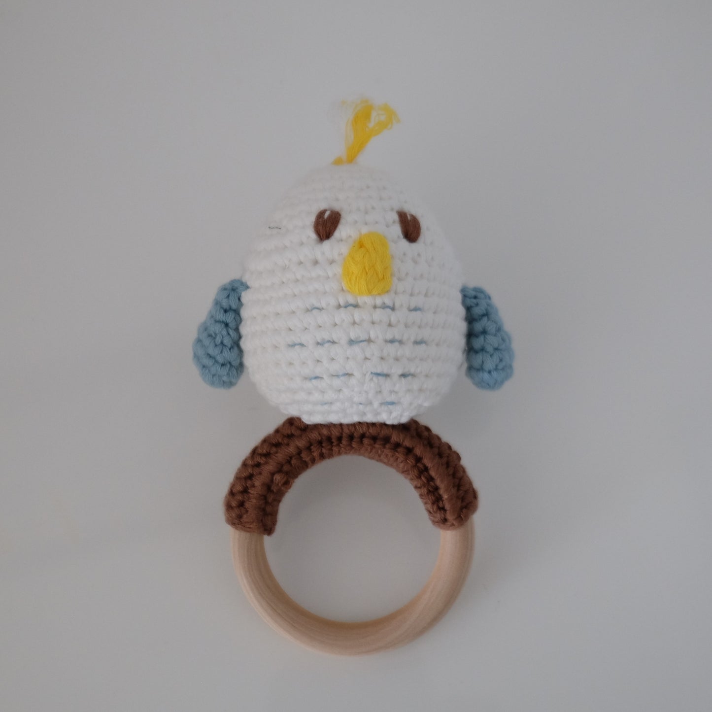 Handmade crochet rattle with a wooden ring base