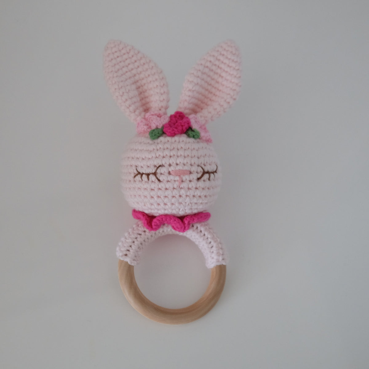 Handmade crochet rattle with a wooden ring base