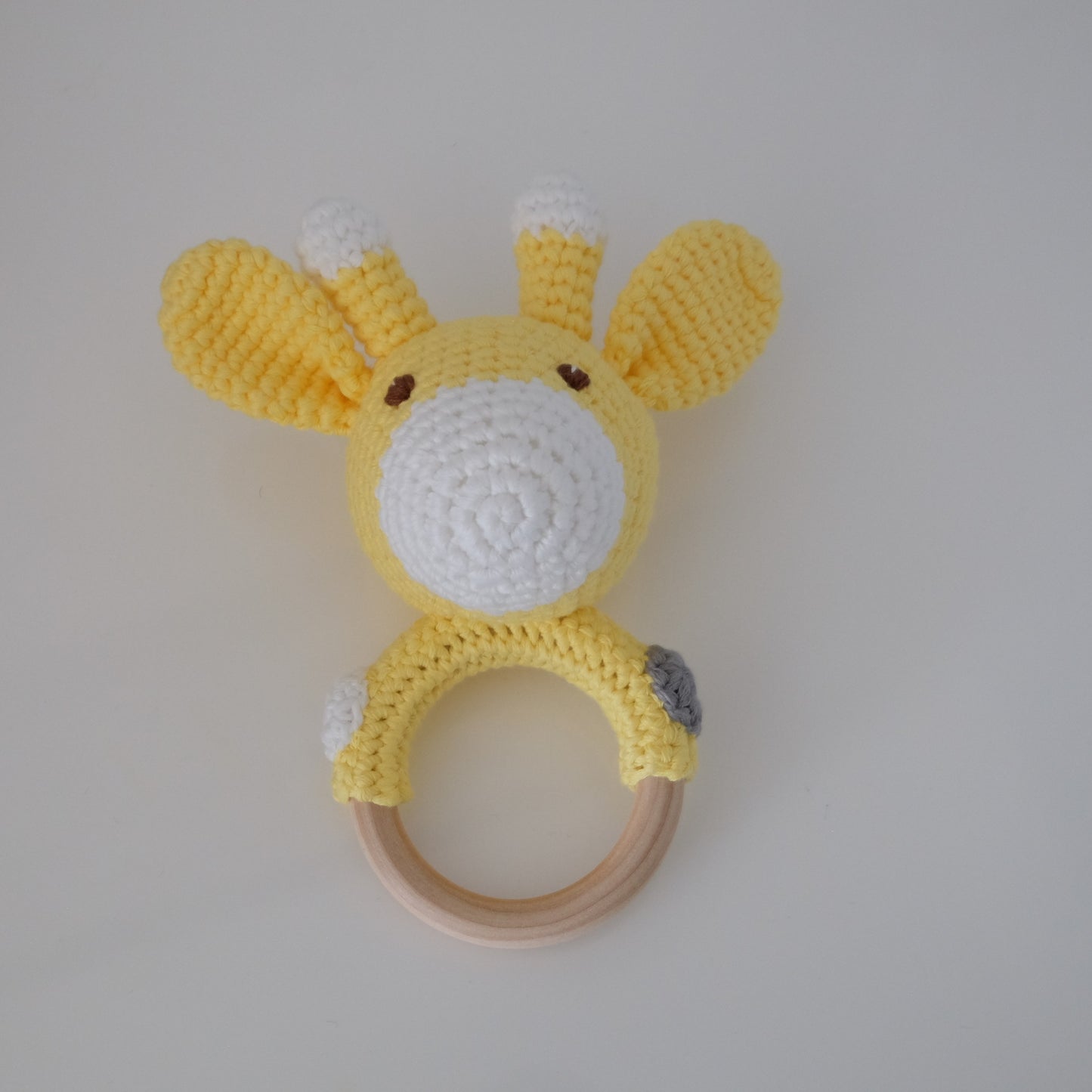 Handmade crochet rattle with a wooden ring base