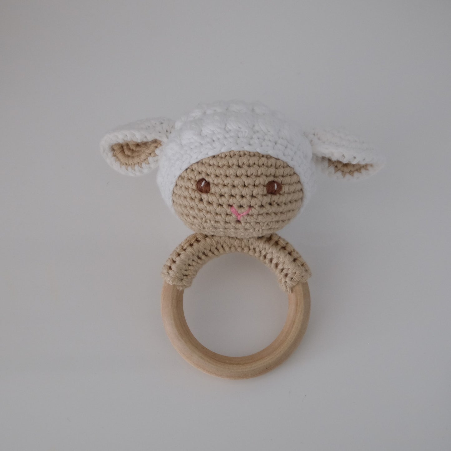 Handmade crochet rattle with a wooden ring base